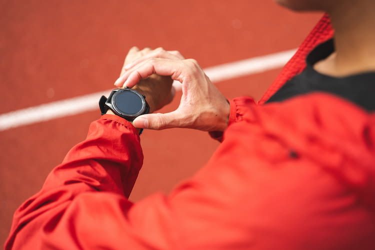 Sportler guckt auf Smartwatch am Handgelenk