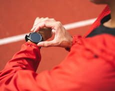 Sportler guckt auf Smartwatch am Handgelenk
